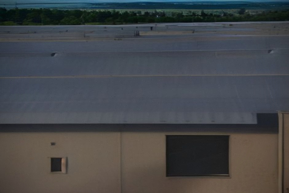 Bâtiment municipal avec panneaux solaires et technicien en inspection sur site